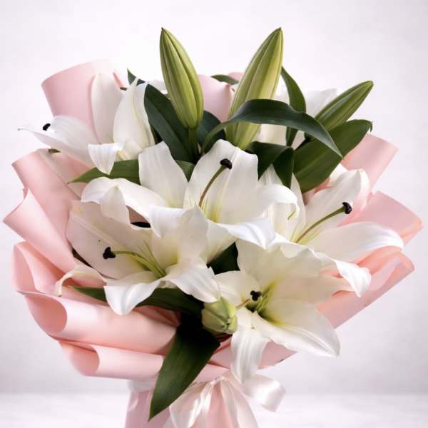 White lilies wrapped in pink paper with a ribbon