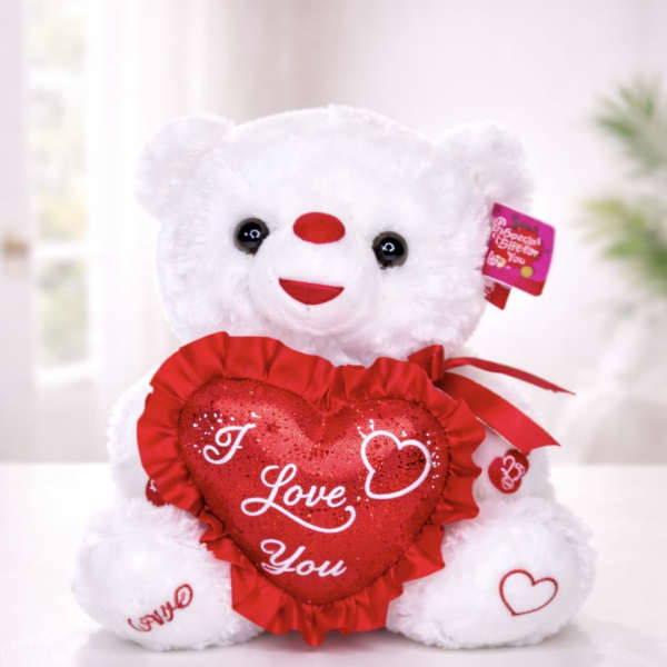 White teddy bear holding a red heart pillow with "I Love You" text