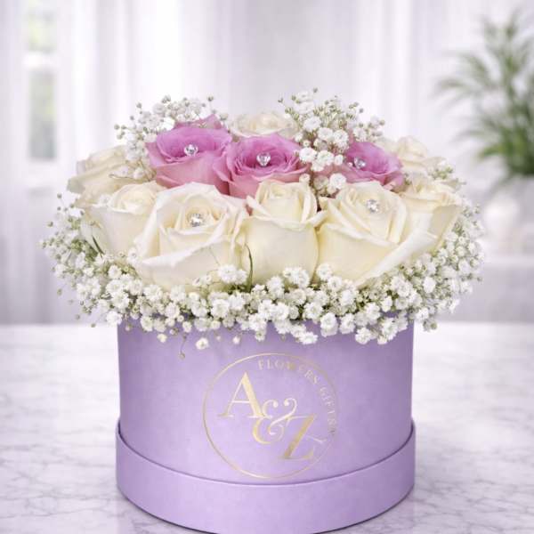 Pink and white roses arranged in a lavender hat box