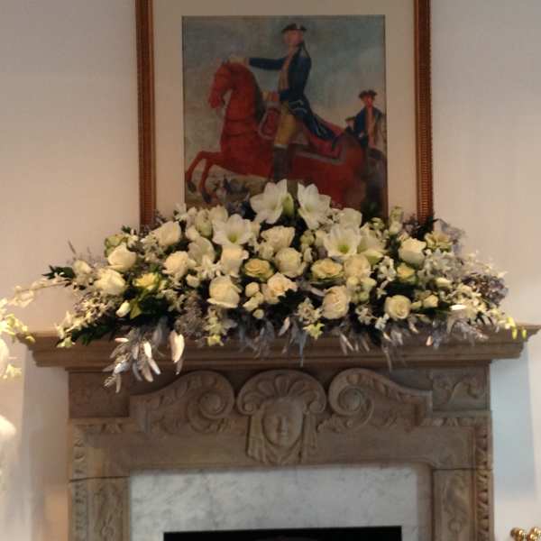 Large white floral arrangement displayed on a mantel