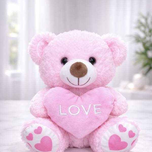 Pink teddy bear holding a heart that says LOVE