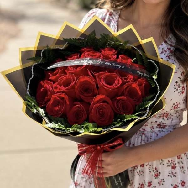 Bouquet of red roses wrapped in black and gold paper