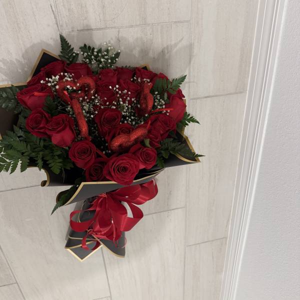 Bouquet of red roses with baby's breath and a red ribbon wrap
