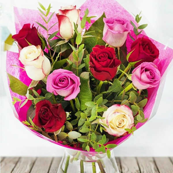 Bouquet of red, pink, and white roses in clear glass vase