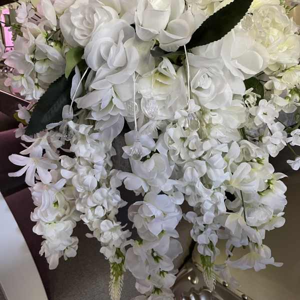 Large white floral arrangement with cascading blooms and pale pink accents