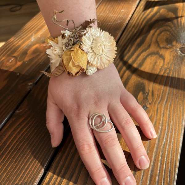 Dried flower wrist corsage on a hand