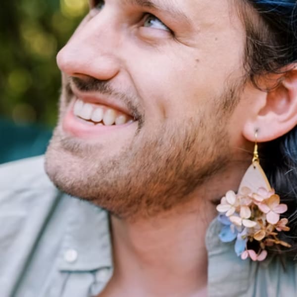 Person wearing a floral earring with small pastel blossoms