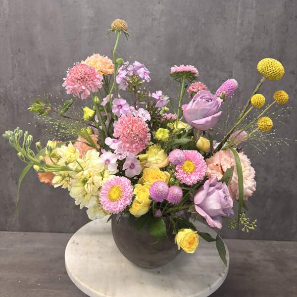Mixed pastel flower arrangement in a dark vase