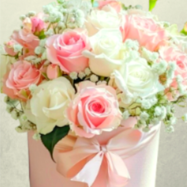 Pink and white roses in a pastel hatbox with a ribbon bow