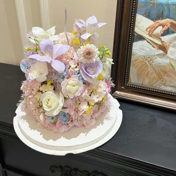 Pastel floral arrangement on a white round base