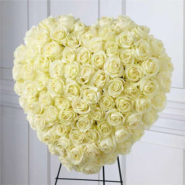 Large heart-shaped bouquet of cream roses on a stand