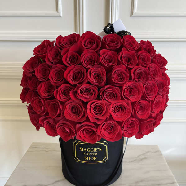 Large bouquet of red roses in a black hatbox