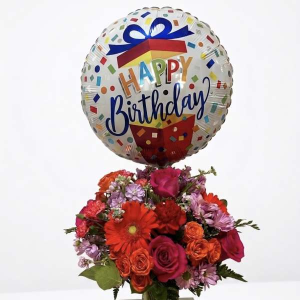 Birthday balloon above a colorful bouquet in a glass vase