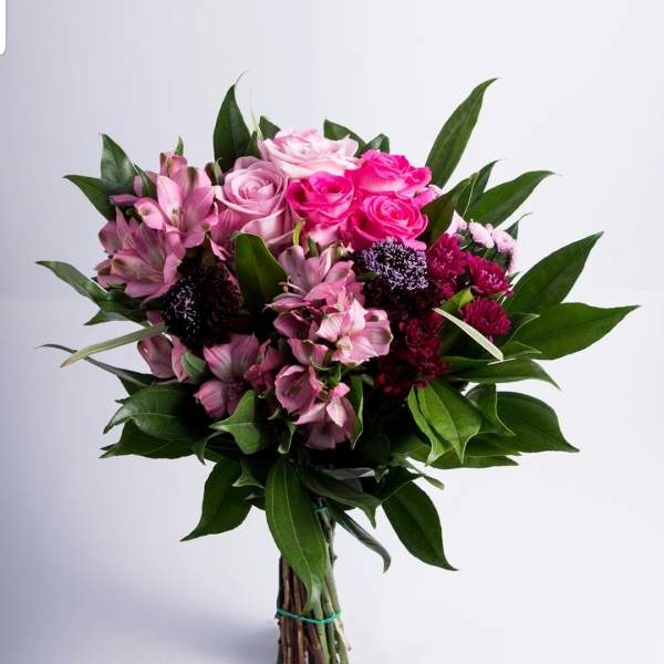 Bouquet of pink roses and alstroemeria with dark green foliage
