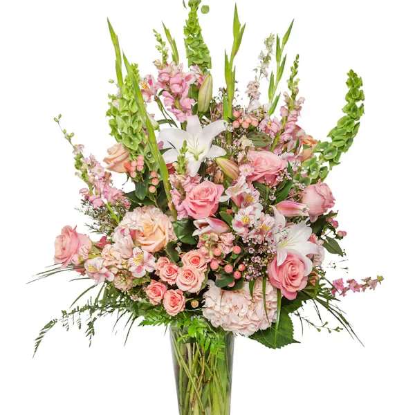 Tall pink and white floral arrangement in a glass vase