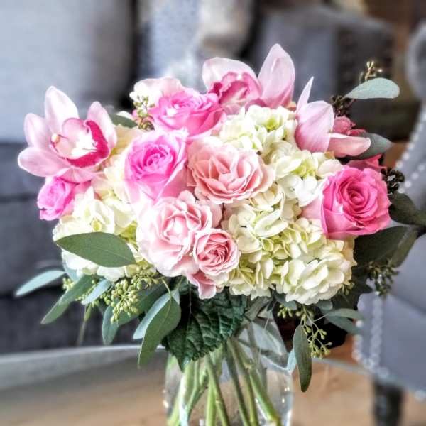 Pink roses and white hydrangeas arranged in a clear glass vase