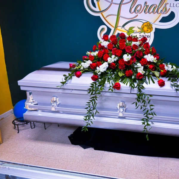 Red and white floral spray on a silver casket