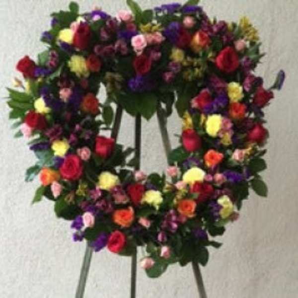 Colorful floral wreath on a stand with mixed roses and small blooms