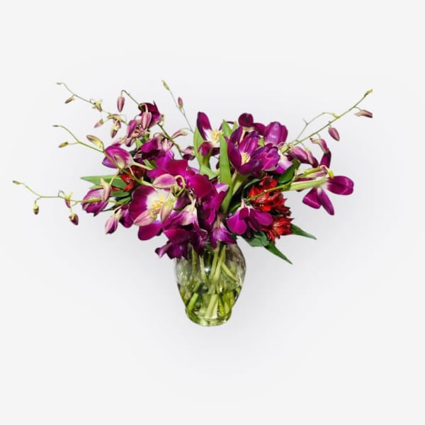 Purple orchid bouquet in a clear glass vase