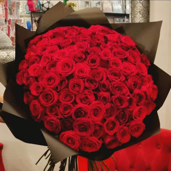 Large bouquet of red roses wrapped in black paper