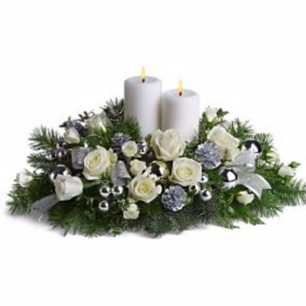 White roses and candles in a low holiday centerpiece
