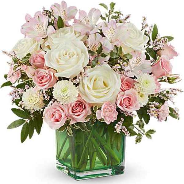 Pink and white roses with alstroemeria in a green glass vase