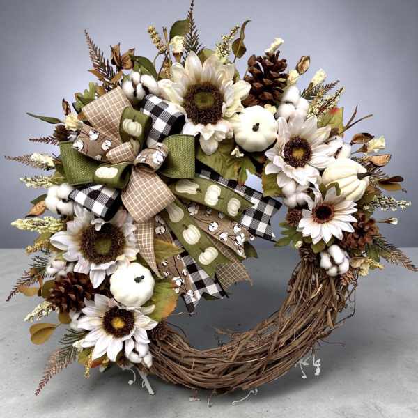 Autumn wreath with sunflowers, cotton bolls, pinecones, and ribbon bows