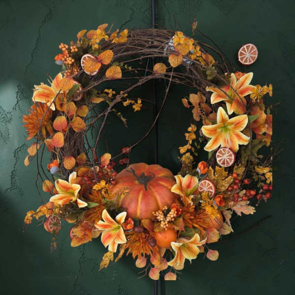 Autumn wreath with orange lilies and a pumpkin centerpiece