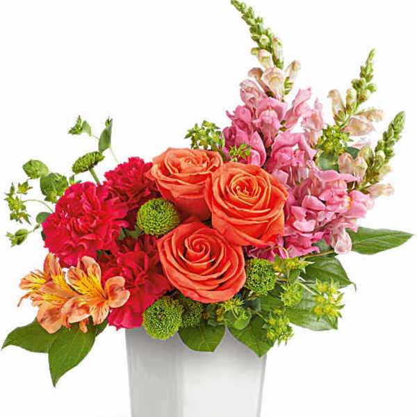Mixed bouquet of orange roses, pink flowers, and green accents in a clear vase