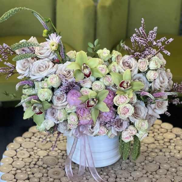 Large pastel flower arrangement in a white container