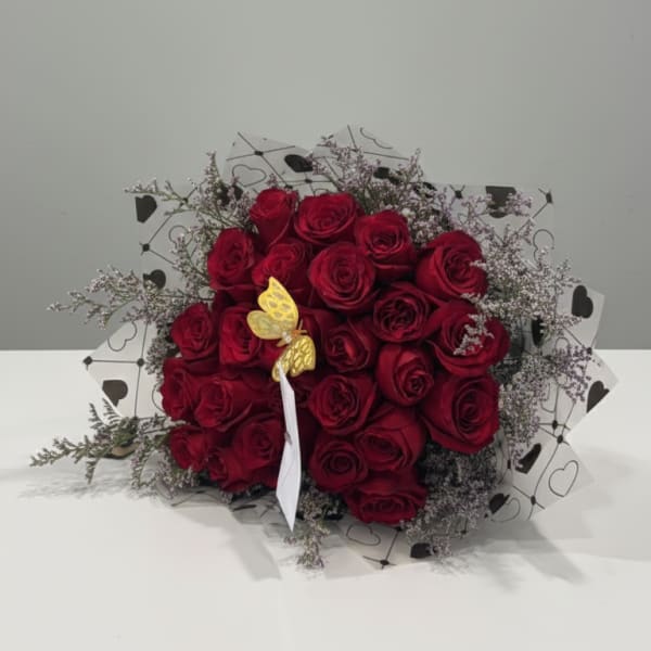 Bouquet of red roses with delicate filler and heart-patterned wrap