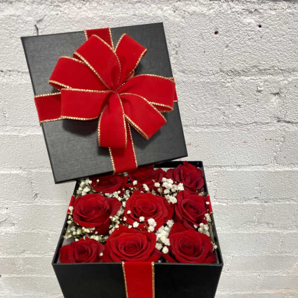 Black gift box with red roses and a large red bow