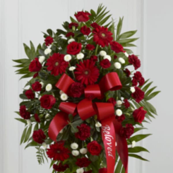 Red floral standing spray with a red ribbon on an easel