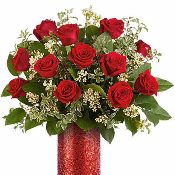 Red roses arranged in a red vase with white filler flowers