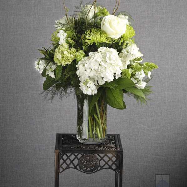 White and green floral arrangement in a clear glass vase