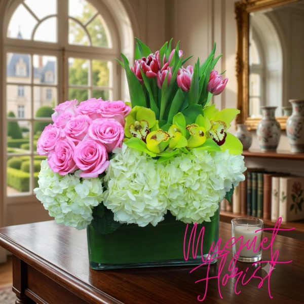 Pink roses, white hydrangeas, and tulips in a green vase with orchids