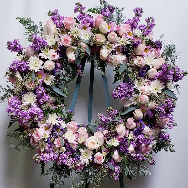 Large heart-shaped wreath of pink and purple flowers on an easel