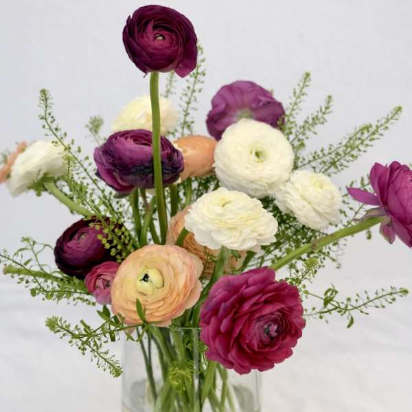 Mixed ranunculus bouquet in a clear glass vase