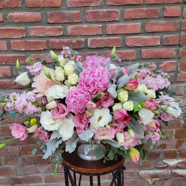 Large pink and white floral arrangement in a silver vase