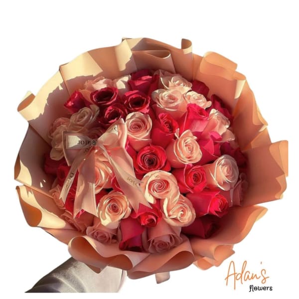 Bouquet of pink and red roses wrapped in peach paper