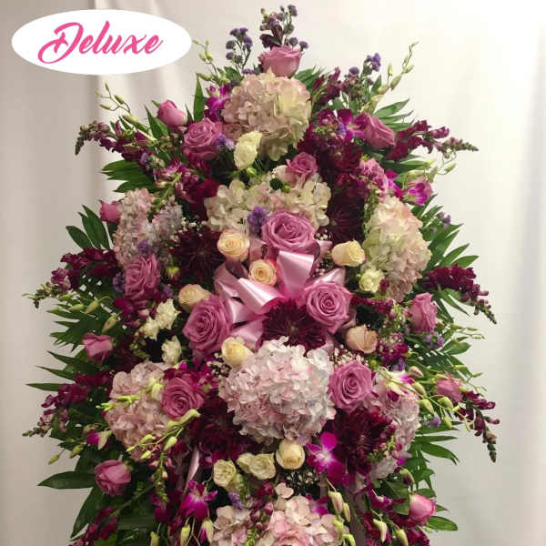 Large pink and purple floral standing spray with ribbon accents