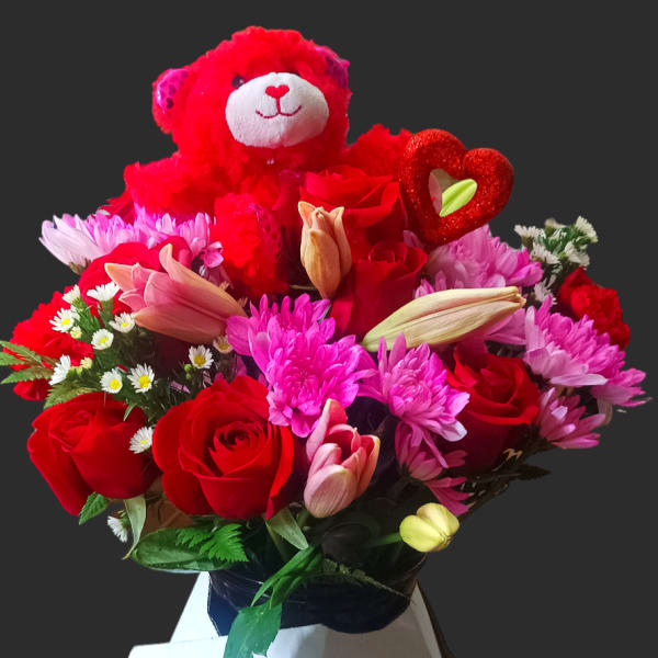 Bouquet of red roses, pink chrysanthemums, and a teddy bear topper