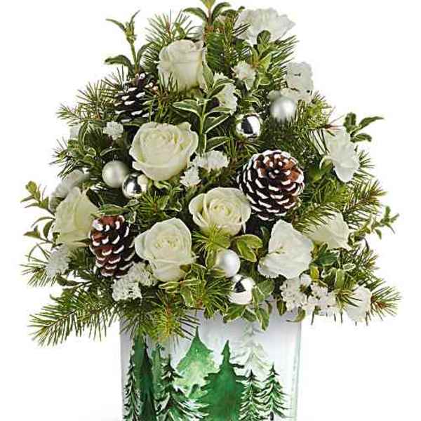 White roses and pinecones in a clear square vase