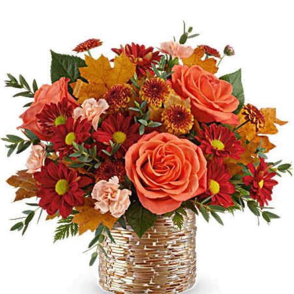 Orange roses and red daisies in a woven basket