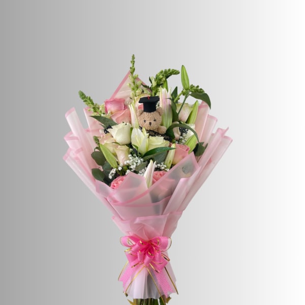 Pink and white bouquet with a teddy bear topper and pink wrapping