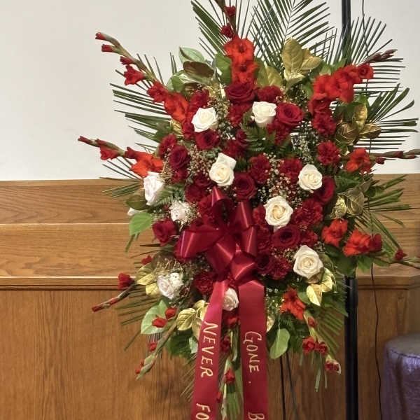 Standing floral spray with red and white roses and red ribbons