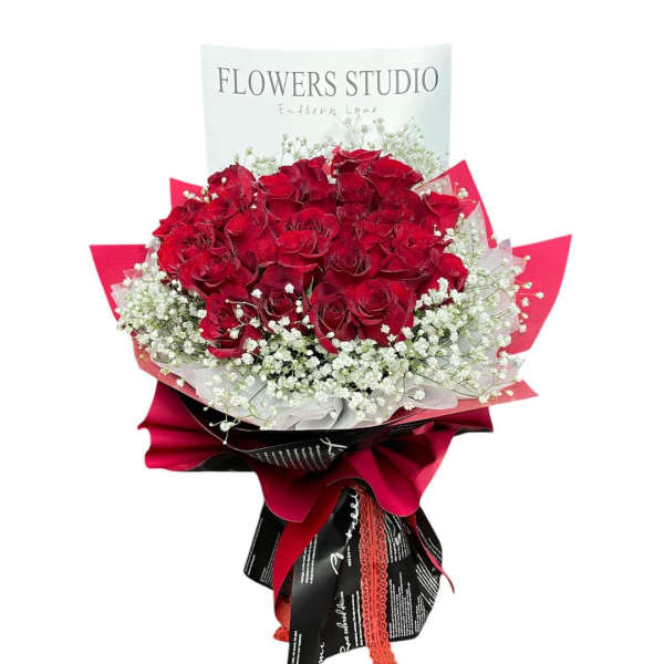 Bouquet of red roses with white baby's breath and red wrapping