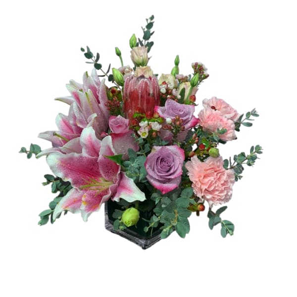 Pink lilies and roses arranged in a black square vase