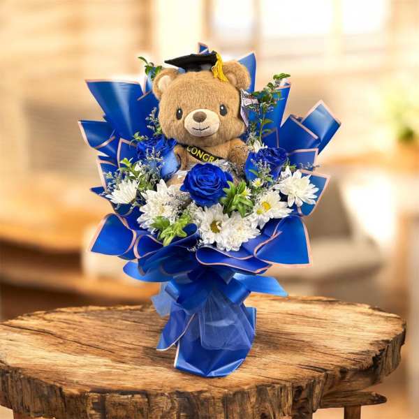 Teddy bear in a blue bouquet with white and blue flowers