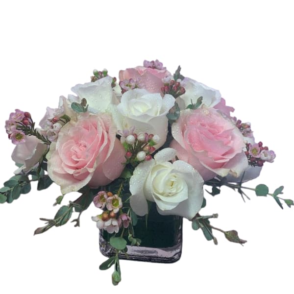 Pink and white rose bouquet in a square glass vase